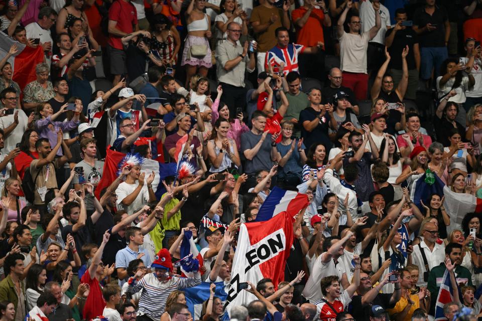 Supporters cheer as France's Leon Marchand (not seen) is called to the podium for the men's 200m individual medley during the Paris 2024 Olympic Games at the Paris Defense Stadium in Nanterre, west of Paris, on August 2, 2024. (Photo by Oli SCARFF/AFP) (Photo by OLI SCARFF/AFP via Getty Images)